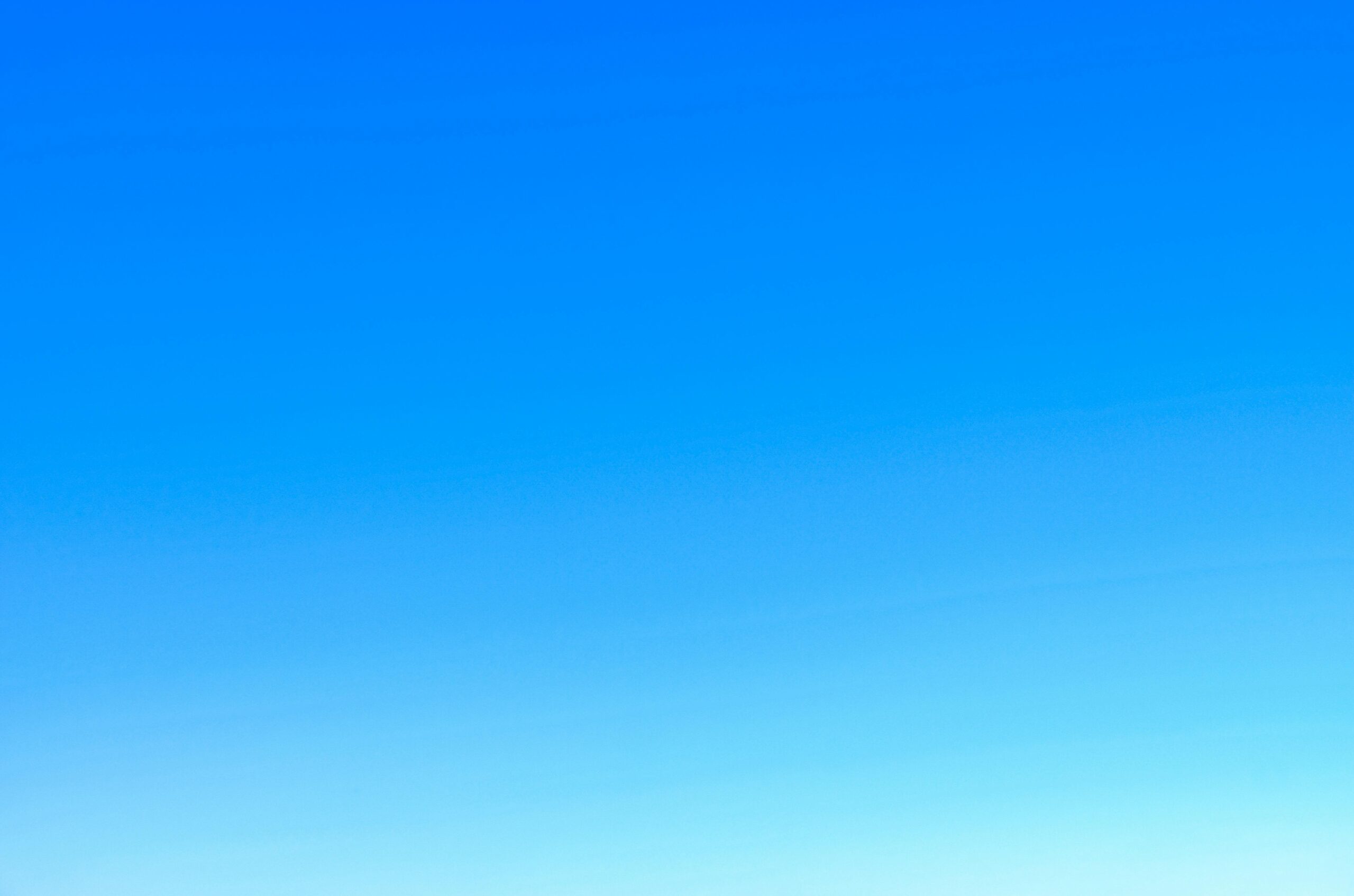 A serene view of a vibrant clear blue sky with a subtle gradient, perfect for backgrounds.